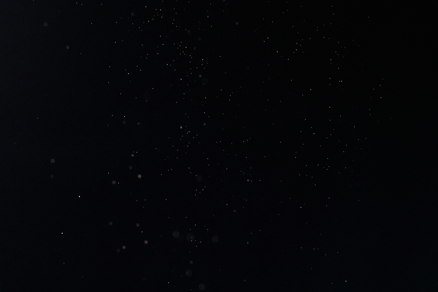 Tiny White Dust Particles on Black Background